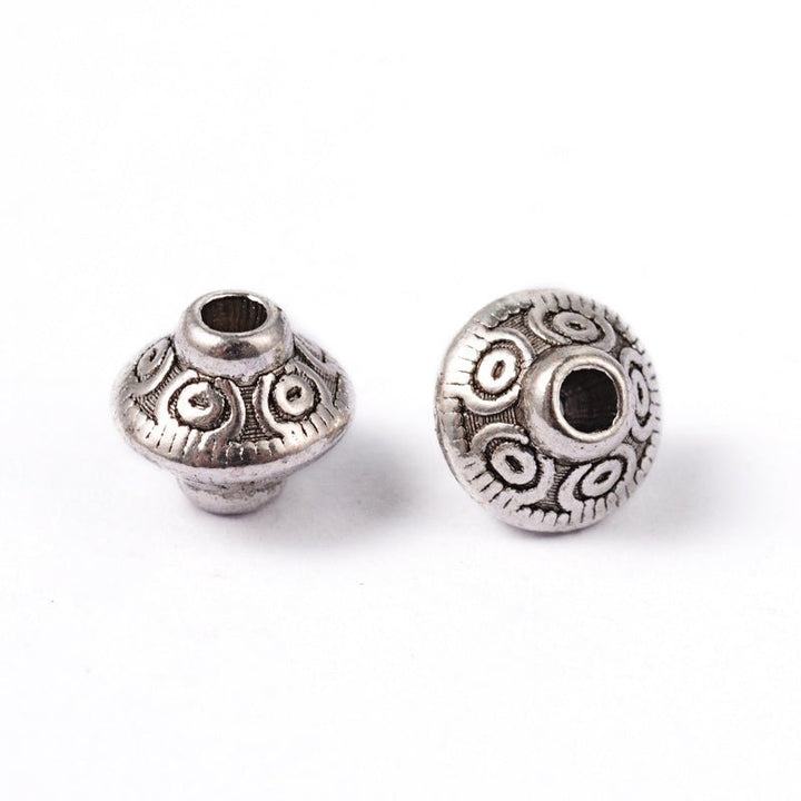 Metallperle im tibetischen Stil 7 x 6,5 mm - Antiksilber - PerlineBeads